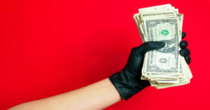 Hand holding lottery money - where does it come from
